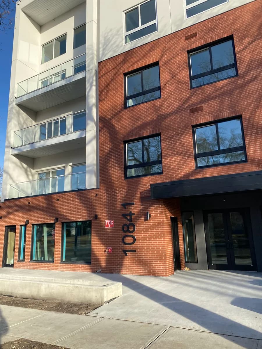 Modern red brick condo entrance with 10841 address